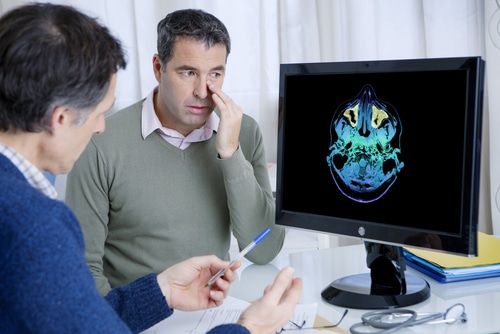 A man in medical check up with doctor discussing his nose problem.