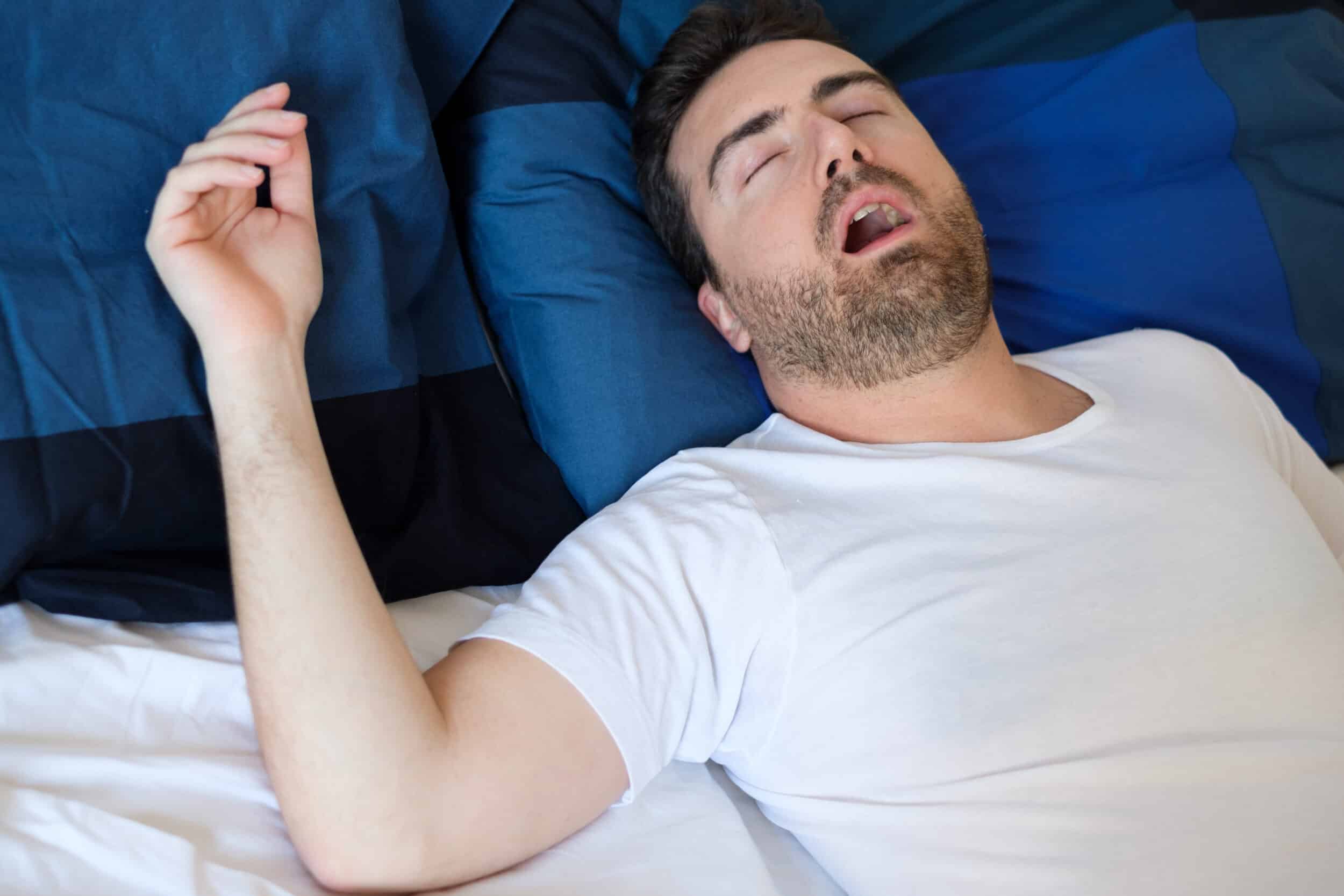 Man in bed snores loudly due to sleep apnea and sinus issues