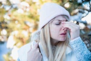 Woman with headache and health problem on winter day outdoor