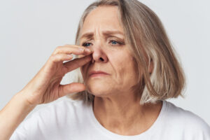 Woman with congestion is irritated by her nose and needs treatment from a sinus specialist.