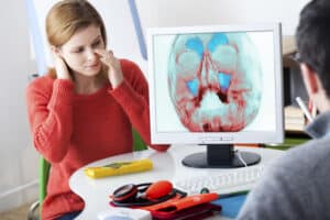 Doctor looks at digital imaging of a woman's sinus prior to surgery